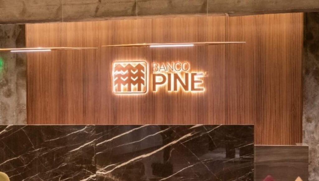 Fachada interna do Banco Pine, destaque para a marca em ambiente corporativo