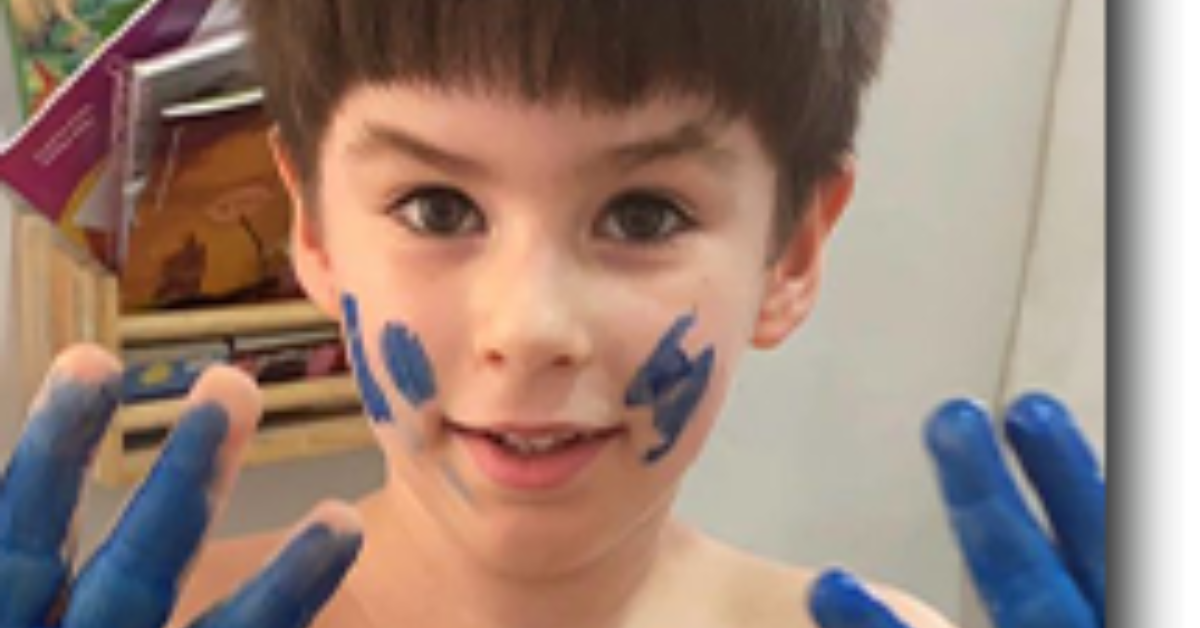 Henry Borel sorrindo com tinta azul nas mãos e no rosto em momento de infância - Foto: Reprodução/MPRJ