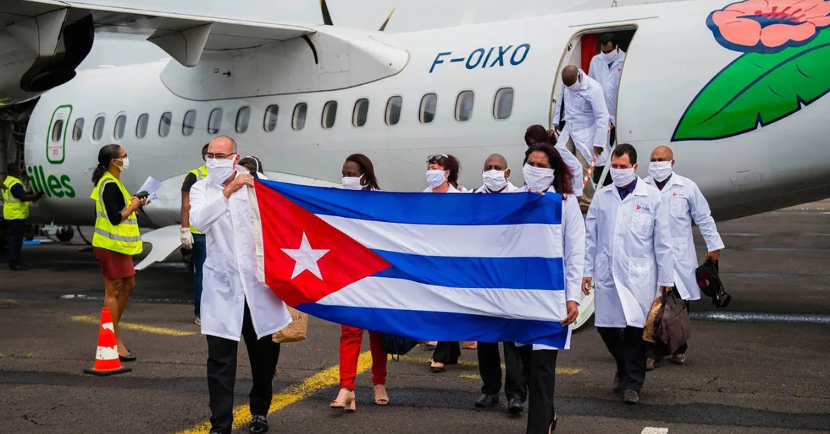 médicos cubanos chegam em missão internacional com bandeira de Cuba - Foto: Reprodução/cuba solidarity campaign