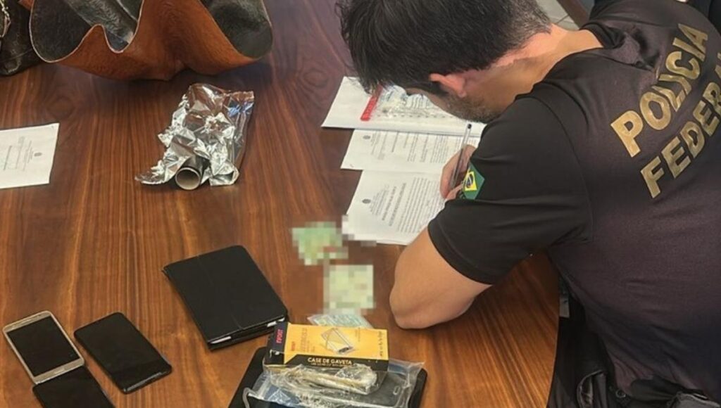 Agente da Polícia Federal durante apreensão de dinheiro e celulares na Operação Fallax