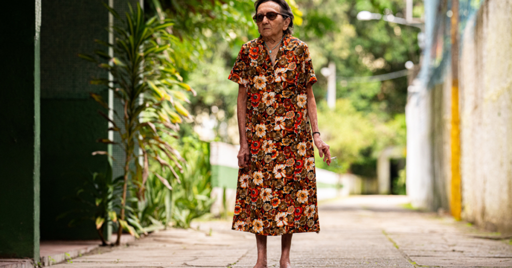 idosa caminhando em rua arborizada em Fortaleza, representando público da programação do cinema do dragão - Foto: Reprodução/Divulgação