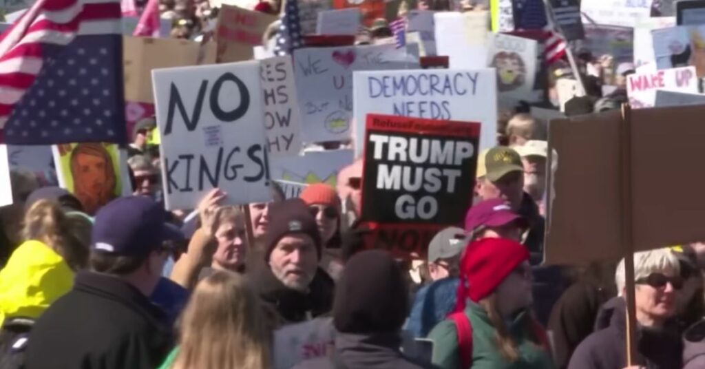Protestos contra Trump nos Estados Unidos com cartazes “No Kings” e “Trump Must Go” em meio à multidão