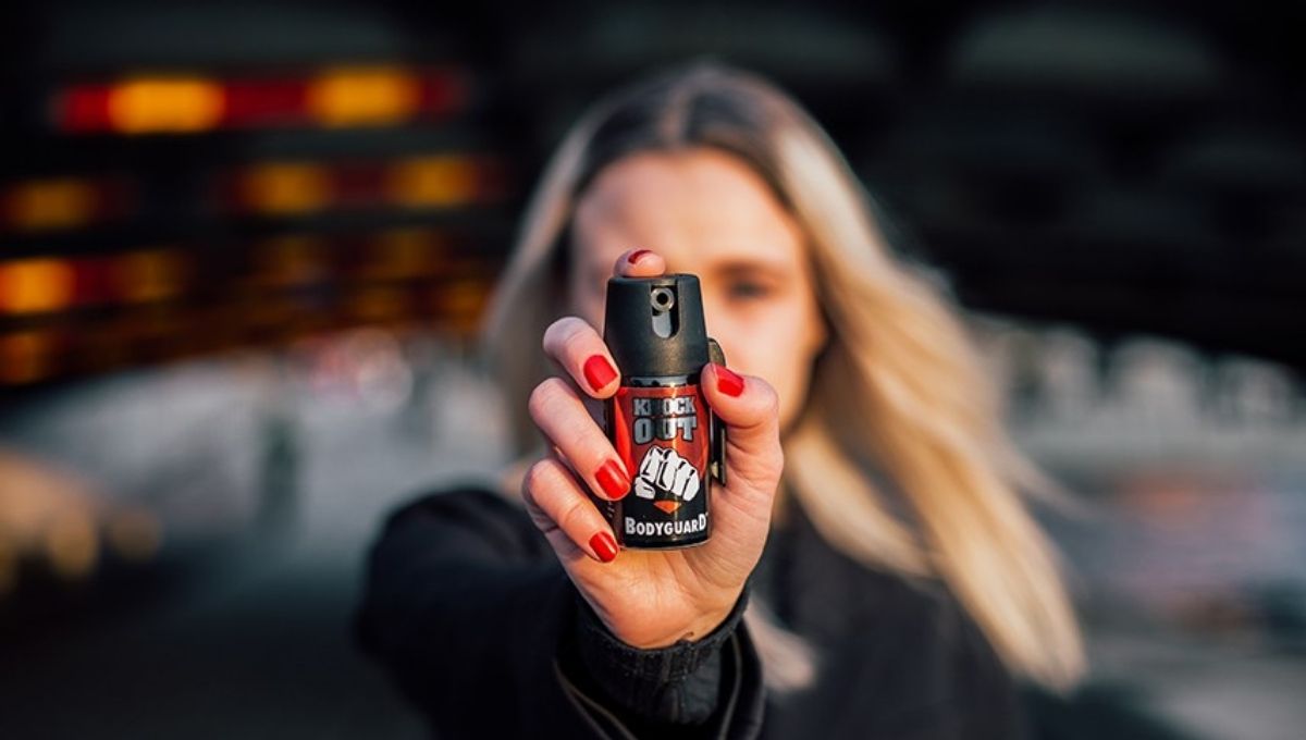 mulher segurando spray de pimenta para autodefesa