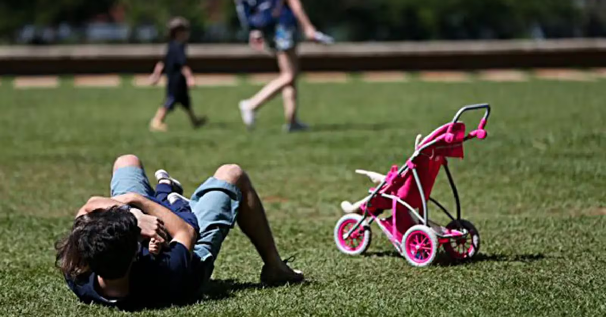 Pai brinca com bebê no gramado durante licença-paternidade ampliada no Brasil - Foto: Reprodução/ Agência Brasil