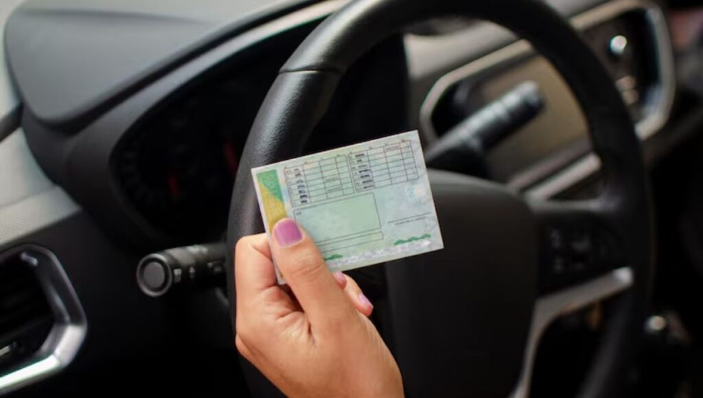 Motorista segurando CNH dentro do carro em contexto de multa da Lei Seca