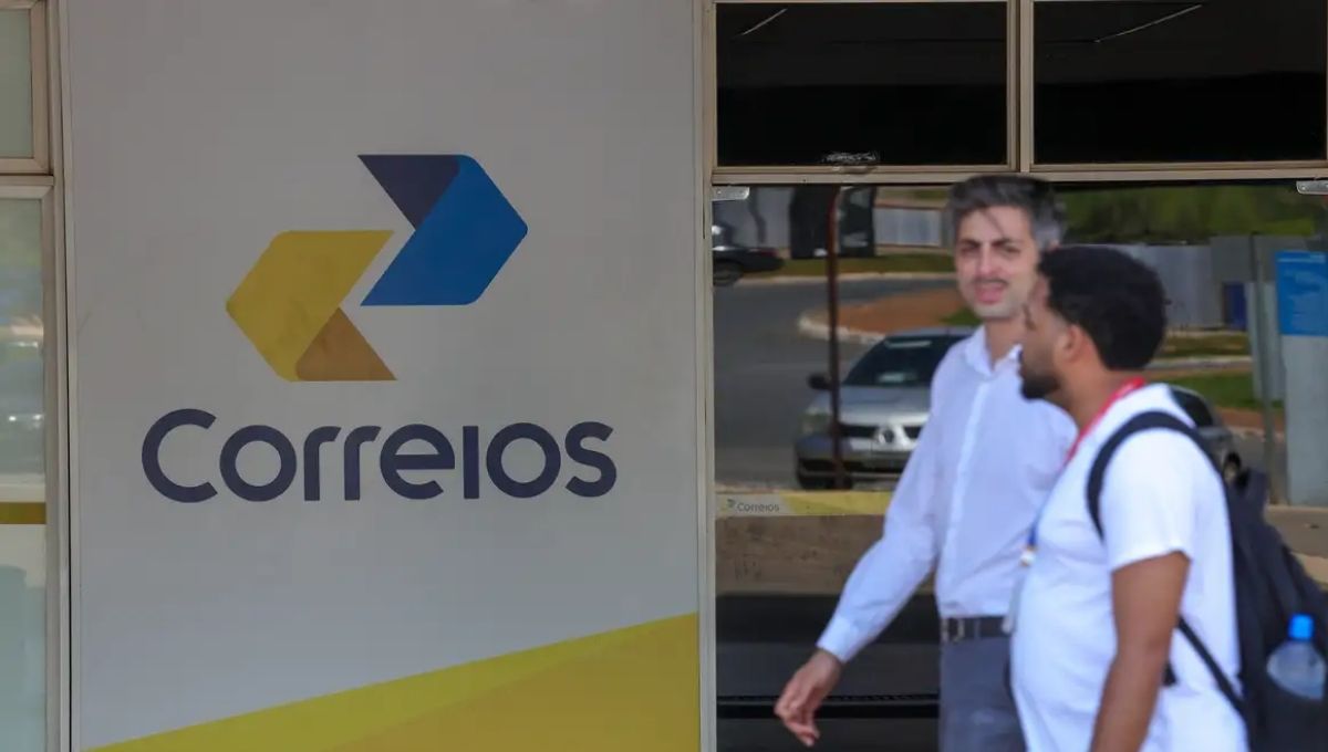 Agência dos Correios com pessoas na entrada em meio ao prejuízo bilionário que afeta fretes e entregas no Brasil