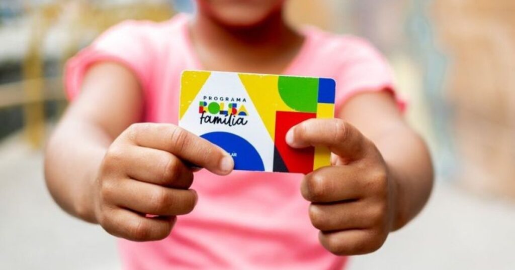 Criança segurando cartão do Bolsa Família em montagem sobre o calendário de pagamentos de junho de 2026 e dados do programa social.