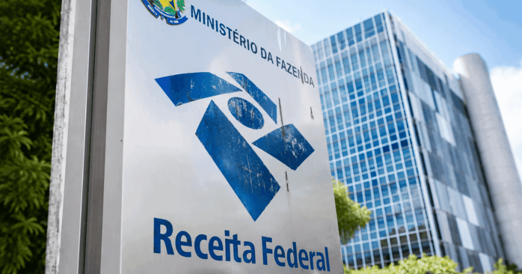 Fachada da Receita Federal com placa institucional do Ministério da Fazenda, tema de reportagem sobre o adiamento da exigência de CNPJ para autônomos até 2027.