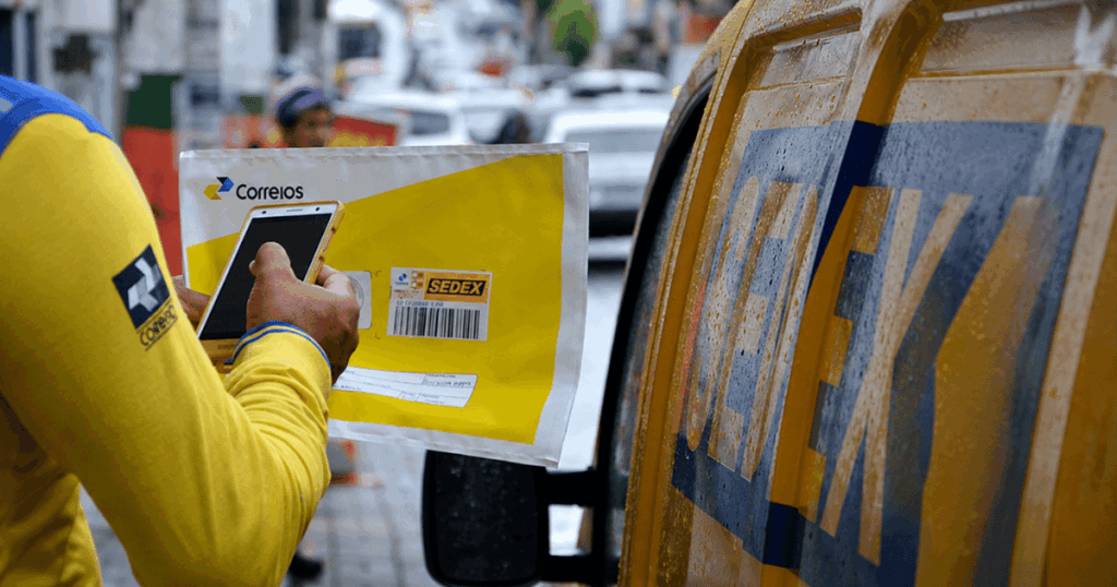 Carteiro dos Correios realiza entrega enquanto governo adia novo empréstimo bilionário à estatal após exigências do TCU.
