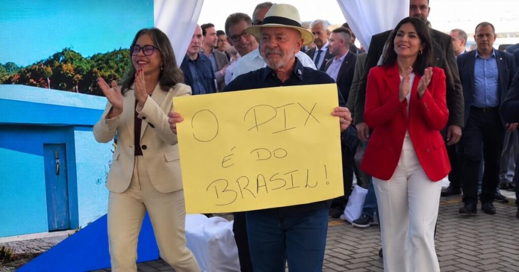 Presidente Lula segura cartaz com a frase “O Pix é do Brasil” durante evento público acompanhado por autoridades e apoiadores.
