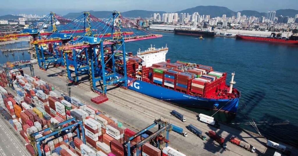 Navio cargueiro em terminal portuário brasileiro com contêineres, representando exportações do Brasil para os Estados Unidos em meio à discussão sobre tarifas comerciais.