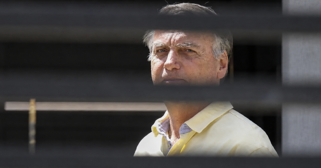 Jair Bolsonaro é visto atrás de grades em imagem utilizada em reportagem sobre questionamentos do STF envolvendo prisão domiciliar e arma apreendida no Distrito Federal.
