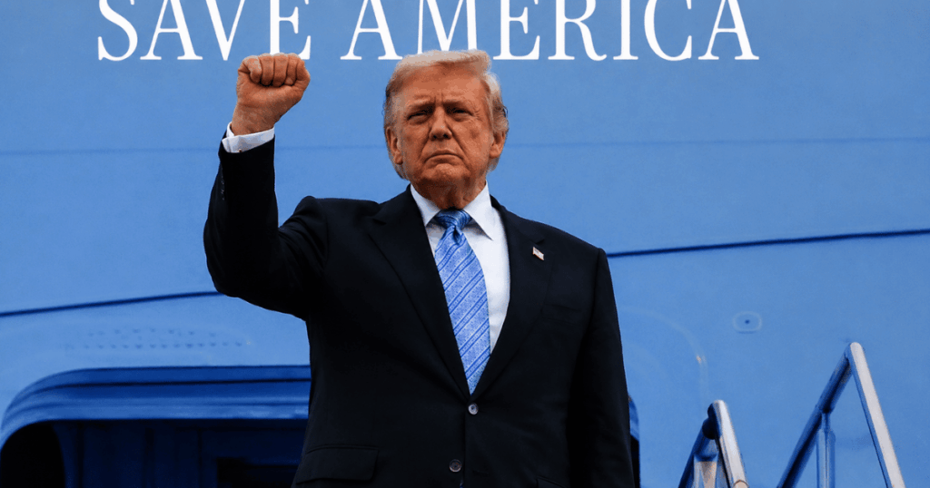 Donald Trump levanta o punho em frente ao avião presidencial após decisão da Suprema Corte dos EUA que ampliou o poder do presidente sobre agências independentes.