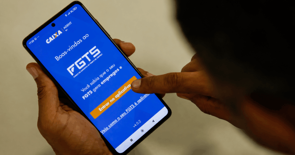 Celular com o aplicativo do FGTS aberto durante consulta ao saldo após a aprovação da distribuição de R$ 13,04 bilhões em lucros.
