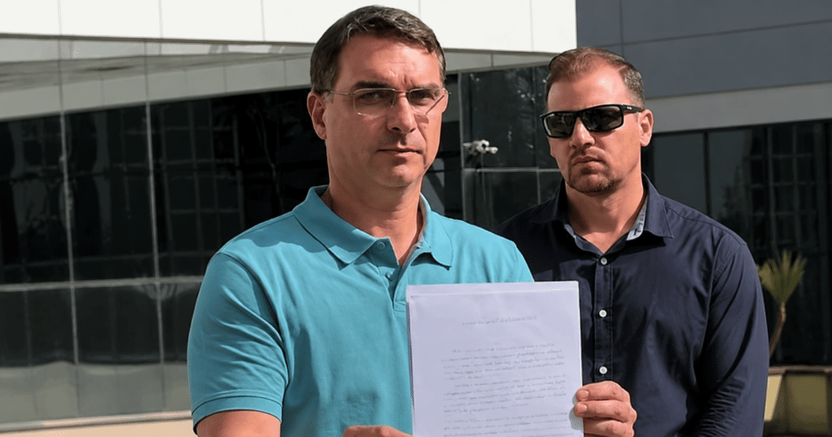 Flávio Bolsonaro segura o ofício enviado ao governo dos Estados Unidos pedindo o adiamento das tarifas de 25% sobre produtos brasileiros por considerar que a medida pode fortalecer Lula politicamente.