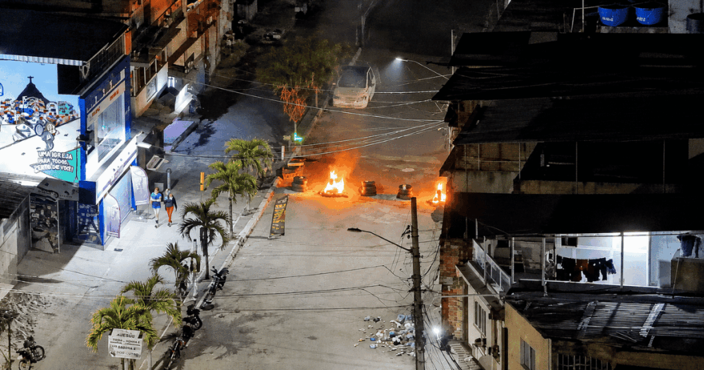 Barricadas em chamas bloqueiam a entrada da Polícia Civil na Vila do João durante a Operação Metástase contra esquema de roubo de medicamentos no Rio de Janeiro.