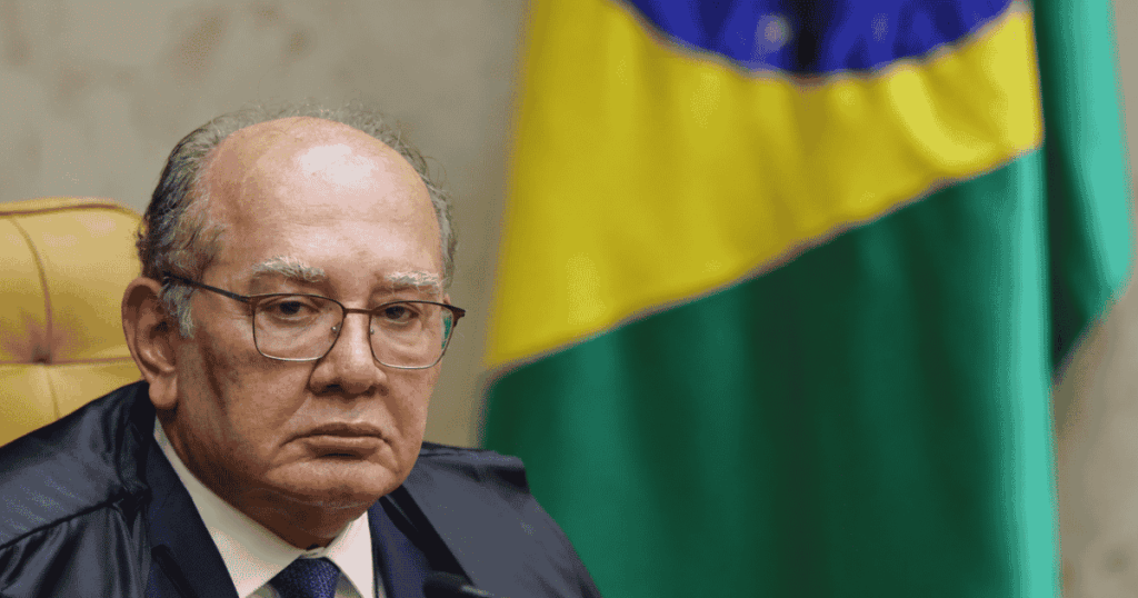 Gilmar Mendes durante sessão, com bandeira do Brasil ao fundo