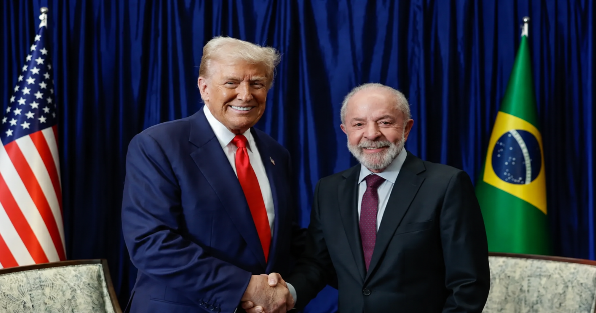 Lula e Donald Trump apertam as mãos durante encontro, com as bandeiras do Brasil e dos Estados Unidos ao fundo