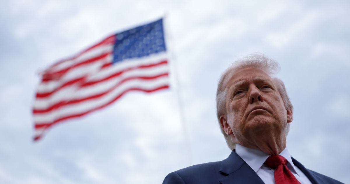 Presidente dos Estados Unidos, Donald Trump, com a bandeira americana ao fundo, em imagem que ilustra a tensão entre EUA e Irã.