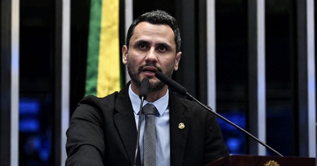 Cleitinho Azevedo discursa em tribuna com microfones durante sessão parlamentar. Matéria aborda o déficit previsto para o governo Cleitinho em 2027.