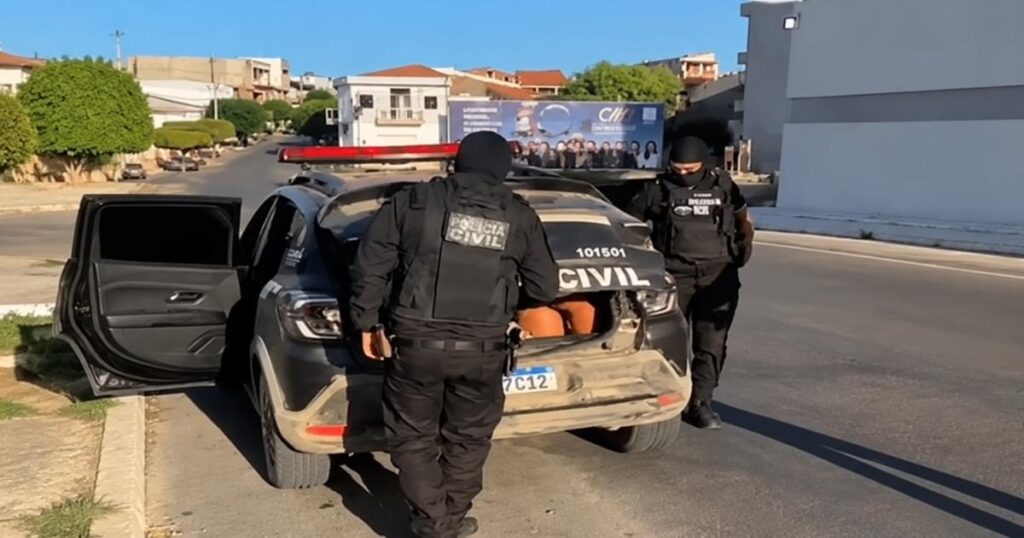 Policiais civis encapuzados atuam ao lado de uma viatura durante operação contra grupo investigado por tráfico de drogas e homicídios em Crateús, no Ceará.
