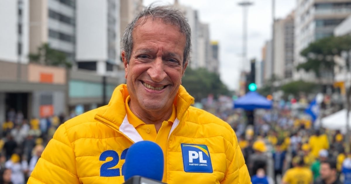 Valdemar Costa Neto durante evento do PL, vestindo jaqueta amarela com símbolo do partido