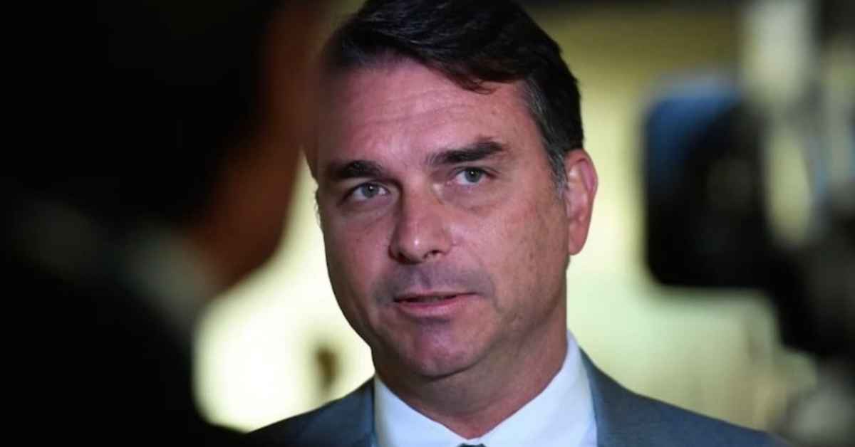 Flávio Bolsonaro, de terno e gravata, durante entrevista a jornalistas